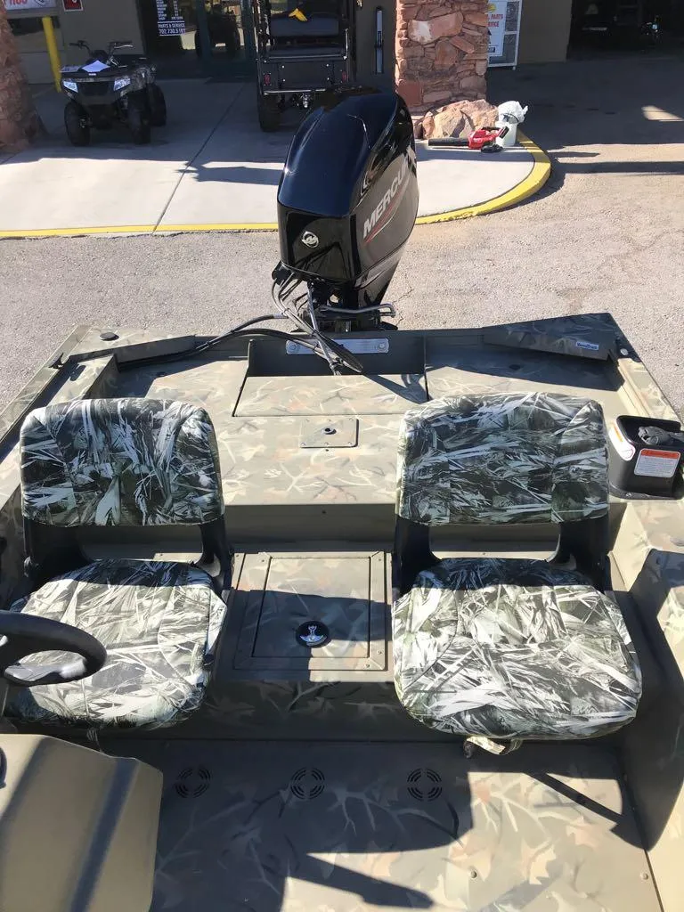 Slide: The Image of 2024 Tracker Grizzly 1754 SC boat with camo seats and Mercury outboard motor. - 9