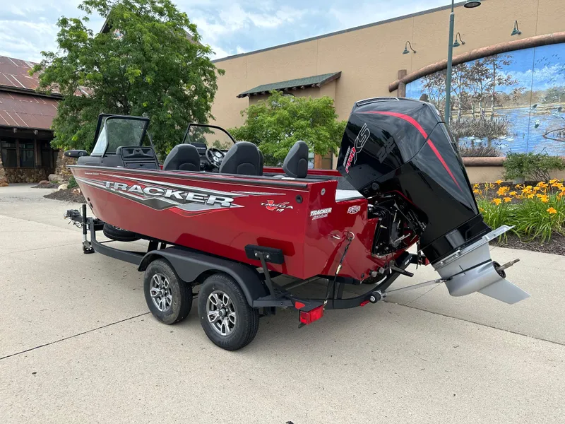 Slide: The Image of 2024 Tracker Targa V-19 WT boat on trailer, red exterior, parked outdoors. - 2