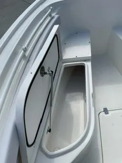 Slide: The Image of 2023 Mako 214 CC boat storage compartment with open hatch. - 10