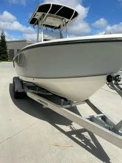 Slide: The Image of 2023 Mako 214 CC boat on a trailer under a clear sky. - 2