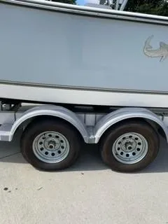 Slide: The Image of 2023 Mako 214 CC boat on a dual-axle trailer. - 6