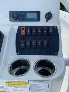 Slide: The Image of Control panel of 2023 Mako 214 CC boat with switches and cup holders. - 7