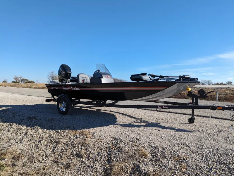 Slide: The Image of 2024 Tracker Bass Tracker Classic XL fishing boat on a trailer in a gravel lot. - 10