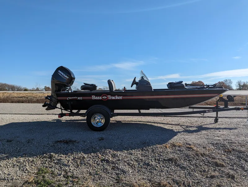 Slide: The Image of 2024 Tracker Bass Tracker Classic XL fishing boat on a trailer in an outdoor setting. - 9