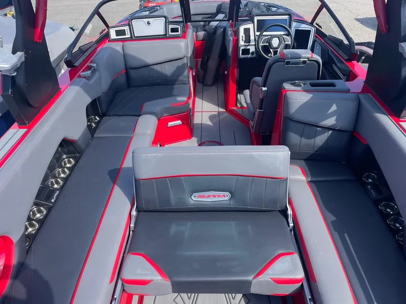 Slide: The Image of 2021 Supra SE boat interior with red and gray seating, modern dashboard, and spacious layout. - 10