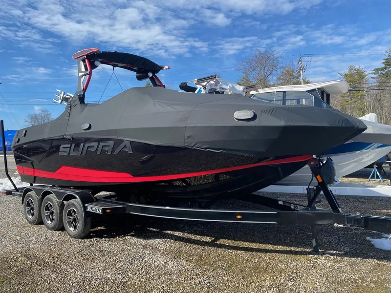 Slide: The Image of 2021 Supra SE boat on a trailer, covered and ready for transport. - 2