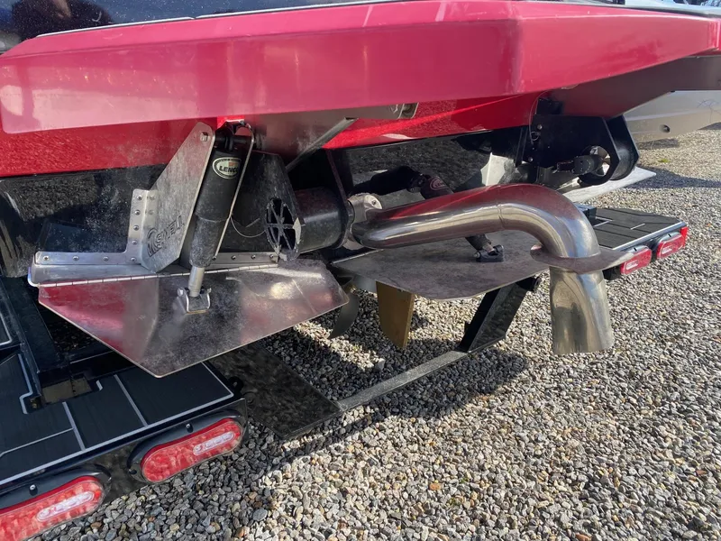 Slide: The Image of Close-up of the rear of a 2021 Supra SE boat showing exhaust and trim tabs. - 5