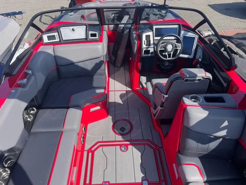 Slide: The Image of 2021 Supra SE boat interior with red and gray seating, modern dashboard, and steering wheel. - 7
