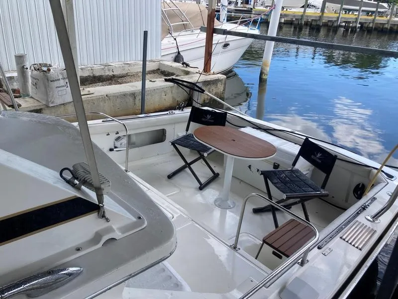 Slide: The Image of 1987 Bertram 28 Sport Fisherman boat with seating area and table at the dock. - 10