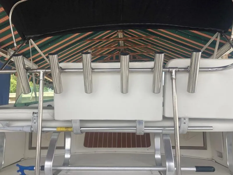Slide: The Image of 1987 Bertram 28 Sport Fisherman boat with rod holders and striped canopy. - 11