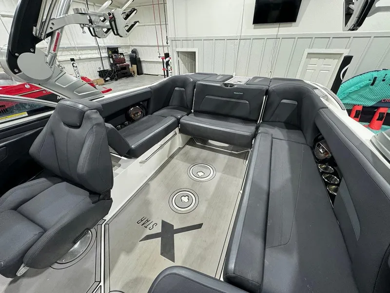 Slide: The Image of 2019 MasterCraft XStar boat interior with black seating and spacious layout. - 19