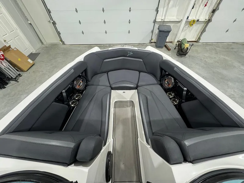 Slide: The Image of 2019 MasterCraft XStar boat interior with gray seating in a garage. - 22