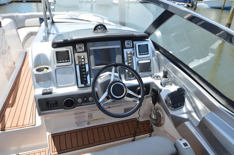 Slide: The Image of 2013 Chaparral 327 SSX boat cockpit with modern controls and steering wheel. - 14