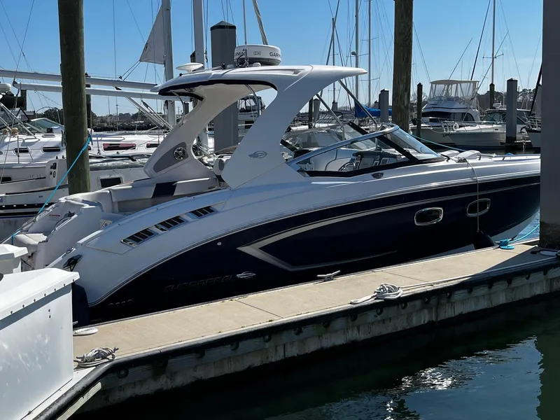 Slide: The Image of 2013 Chaparral 327 SSX boat docked at a marina under clear blue skies. - 2