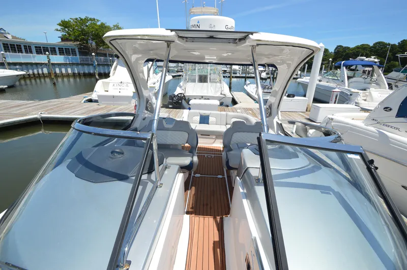 Slide: The Image of 2013 Chaparral 327 SSX boat docked at marina, showcasing sleek design and spacious seating. - 21