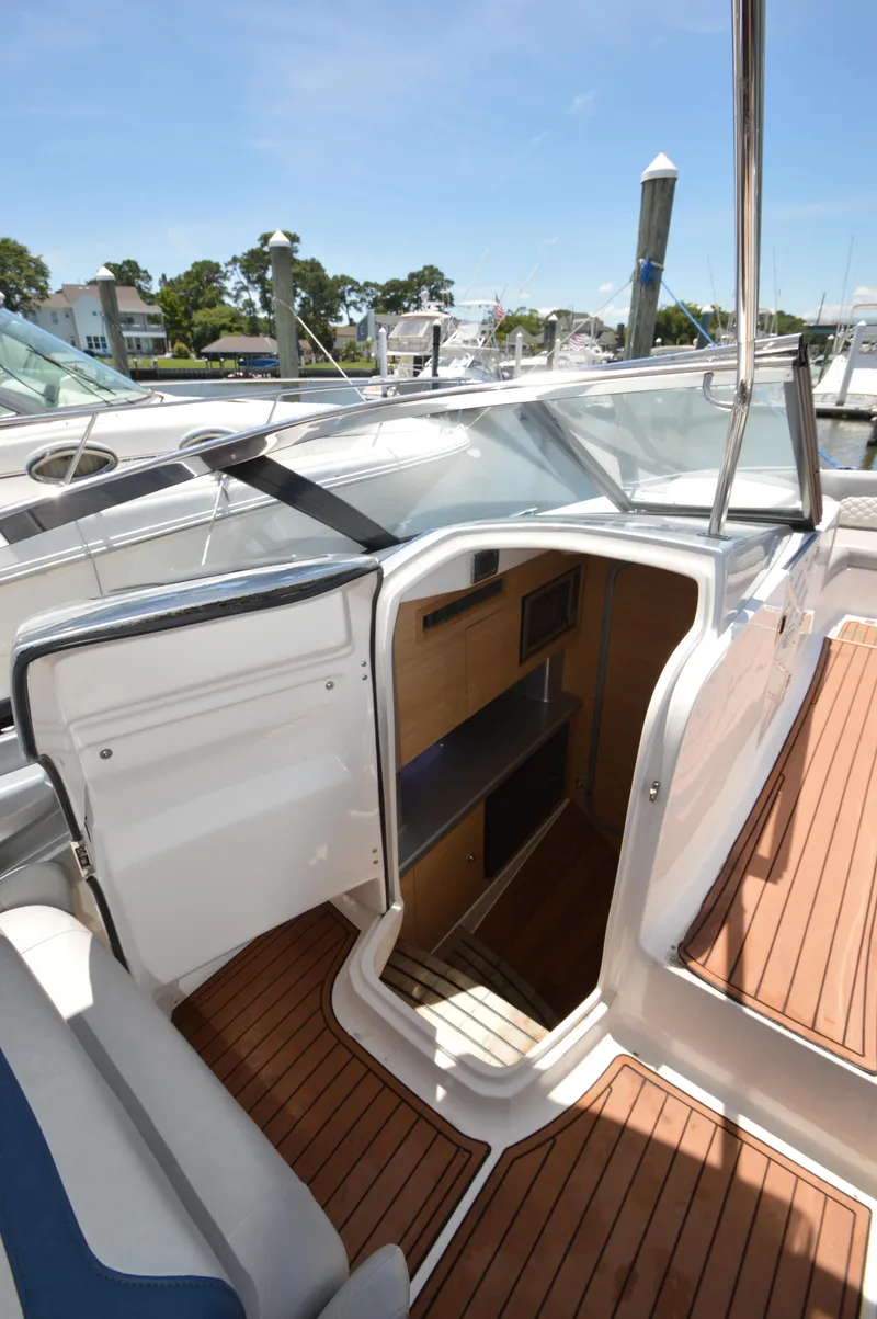 Slide: The Image of 2013 Chaparral 327 SSX boat interior with wood flooring and open cabin door. - 25