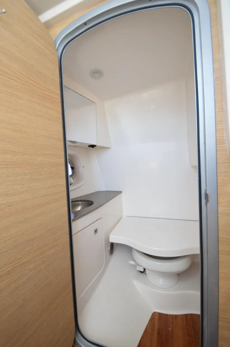 Slide: The Image of 2013 Chaparral 327 SSX boat bathroom with sink, toilet, and wooden accents. - 31