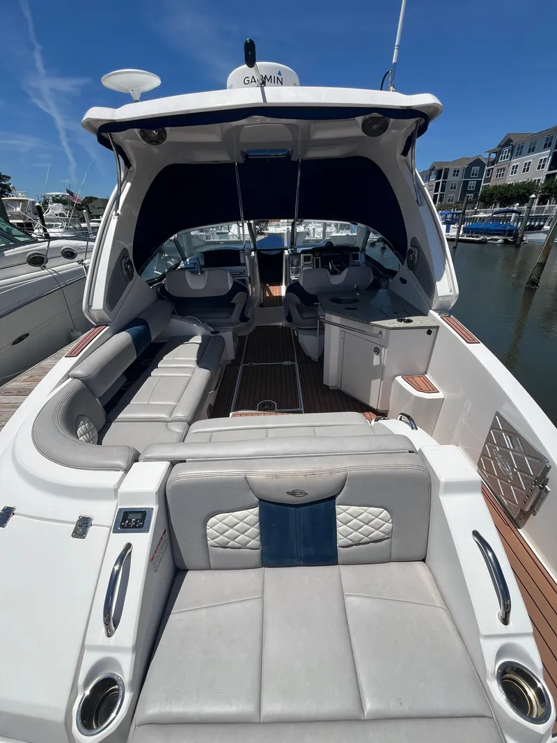 Slide: The Image of 2013 Chaparral 327 SSX boat interior with luxurious seating and modern amenities at a marina. - 4