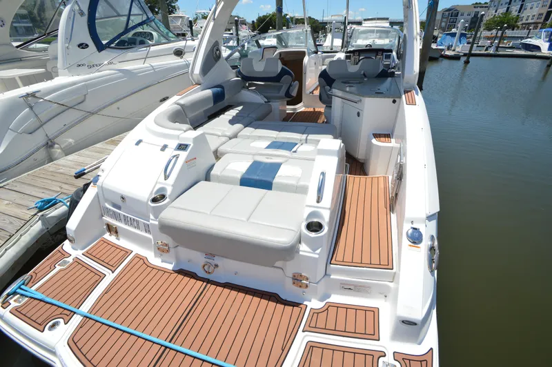 Slide: The Image of 2013 Chaparral 327 SSX boat with spacious seating and teak flooring at a marina. - 7