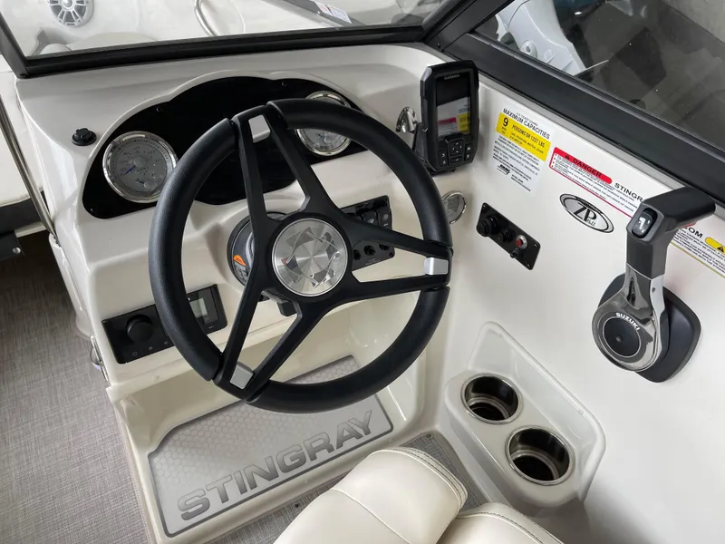 Slide: The Image of 2024 Stingray 191 DC boat dashboard with steering wheel and control panel. - 1