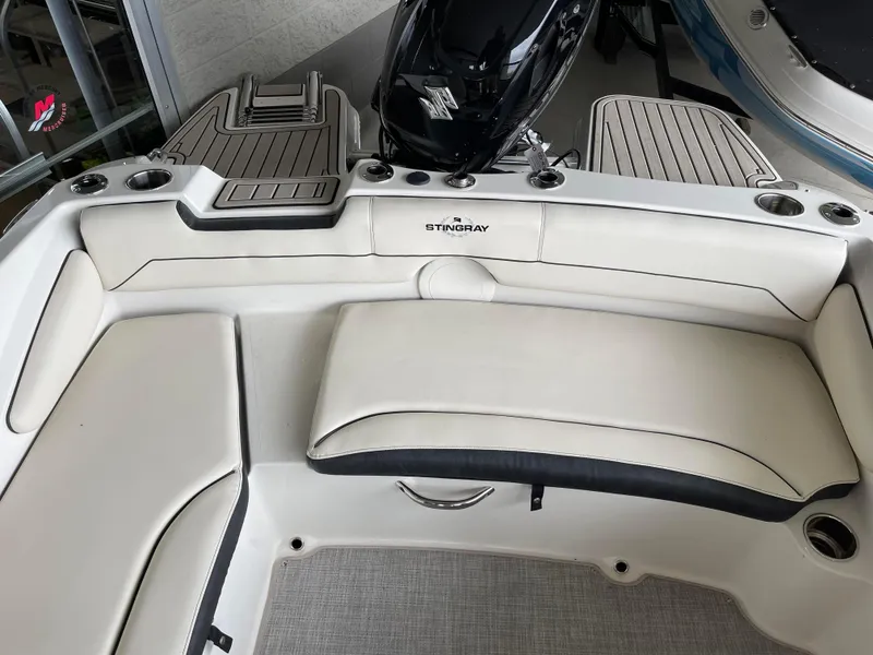 Slide: The Image of 2024 Stingray 191 DC boat interior with cushioned seating and motor. - 12