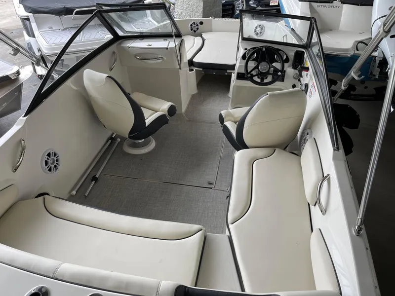 Slide: The Image of 2024 Stingray 191 DC boat interior with white seating and steering console. - 17