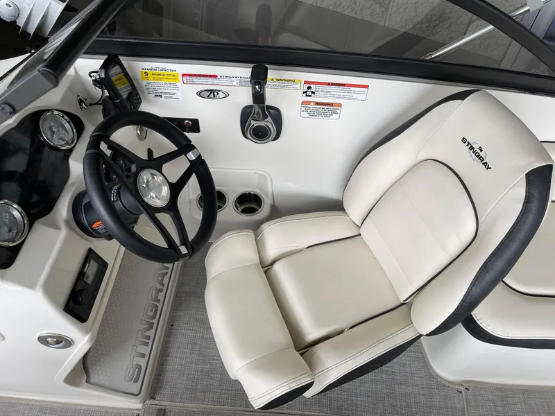 Slide: The Image of 2024 Stingray 191 DC boat interior with steering wheel and captain's chair. - 18