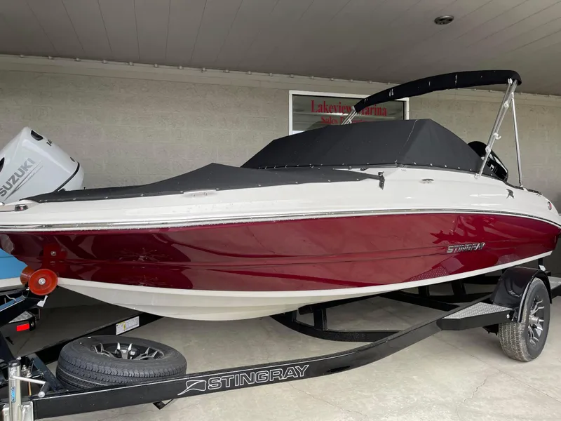 Slide: The Image of 2024 Stingray 191 DC boat with red and white hull on a trailer. - 25