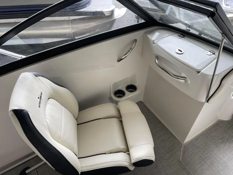Slide: The Image of 2024 Stingray 191 DC boat interior with white captain's chair and dashboard. - 26