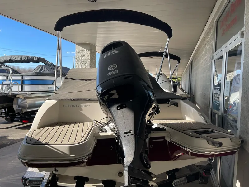 Slide: The Image of 2024 Stingray 191 DC boat with outboard motor, displayed in a showroom. - 28
