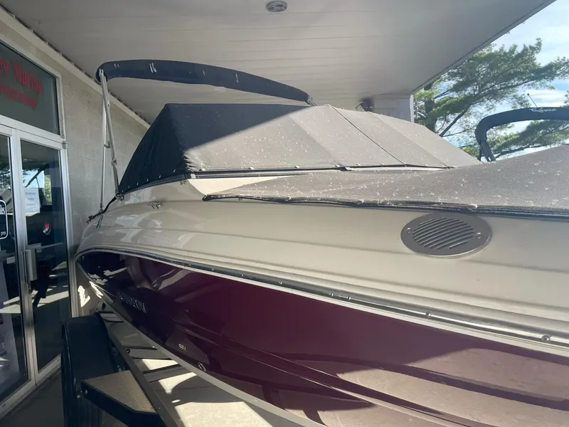 Slide: The Image of 2024 Stingray 191 DC boat with cover, displayed indoors, showcasing sleek design. - 29