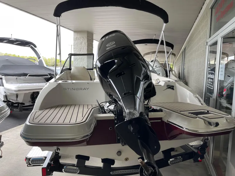 Slide: The Image of 2024 Stingray 191 DC boat with outboard motor, docked in a covered marina. - 3