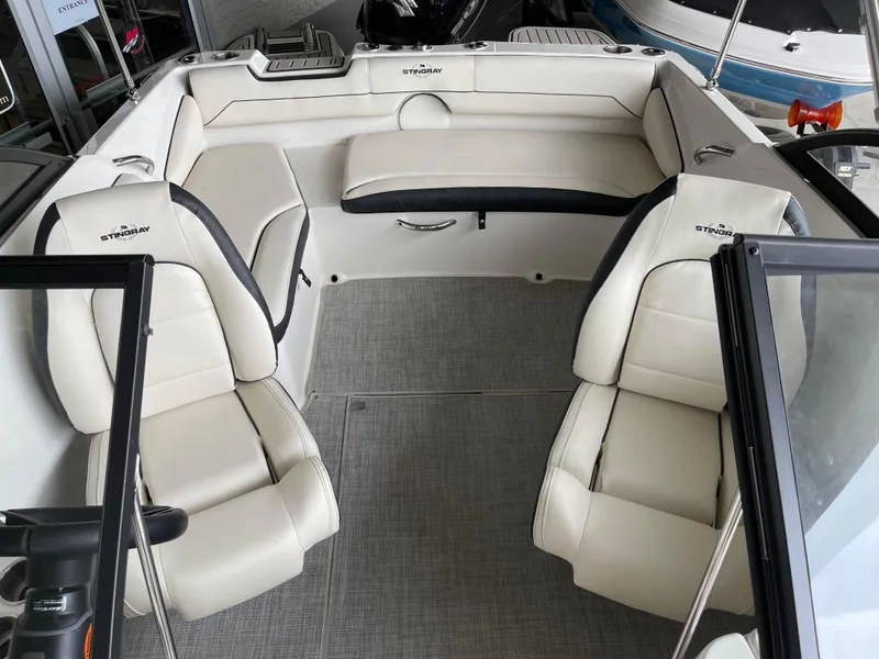 Slide: The Image of 2024 Stingray 191 DC boat interior with white leather seats and spacious layout. - 8