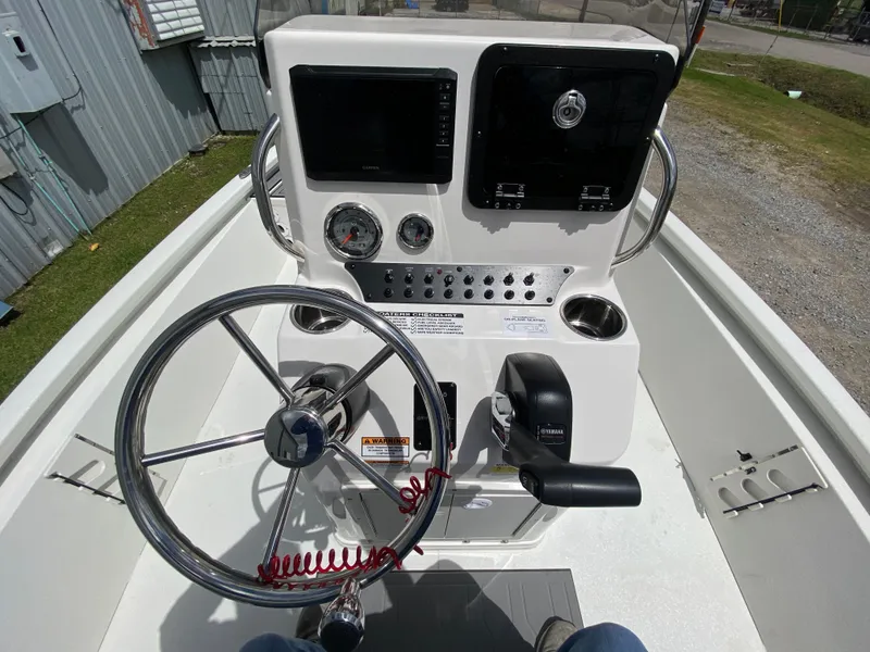 Slide: The Image of 2024 Avid 19FSX boat console with steering wheel, gauges, and controls. - 6