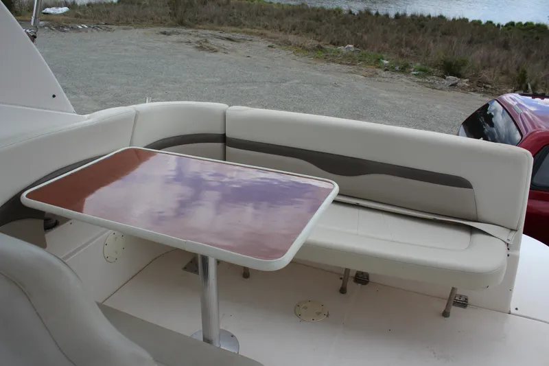 Slide: The Image of 2008 Chaparral Signature 290 boat interior with cushioned seating and wooden table. - 11