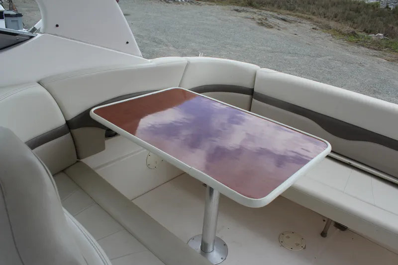 Slide: The Image of 2008 Chaparral Signature 290 boat interior with cushioned seating and wooden table. - 12
