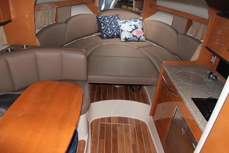 Slide: The Image of 2008 Chaparral Signature 290 interior with cozy seating, wooden flooring, and compact kitchen area. - 27
