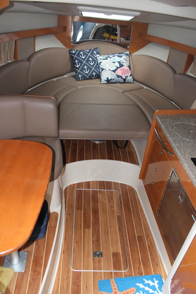 Slide: The Image of 2008 Chaparral Signature 290 interior with cozy seating, nautical pillows, and wood flooring. - 28