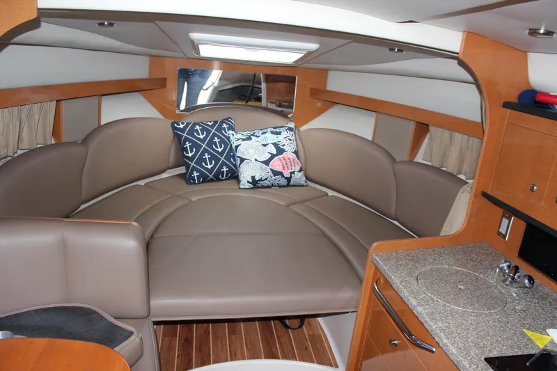 Slide: The Image of 2008 Chaparral Signature 290 interior with cozy seating and nautical-themed pillows. - 29