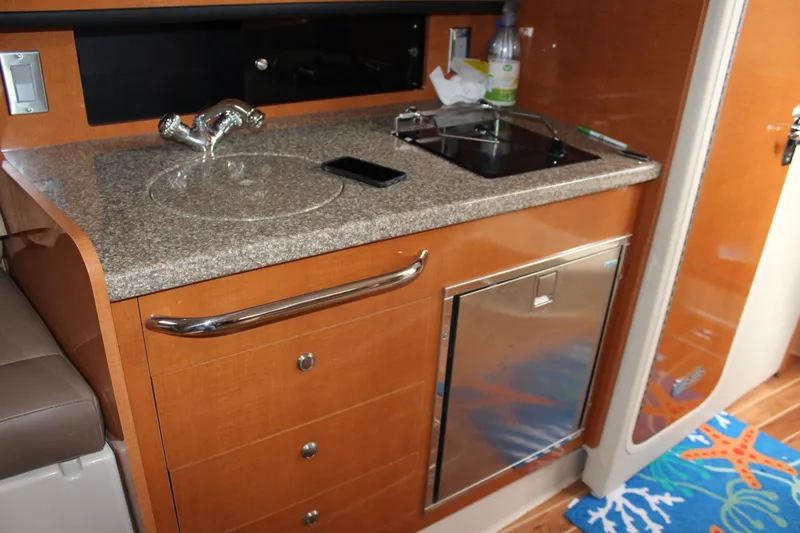 Slide: The Image of 2008 Chaparral Signature 290 boat interior with kitchenette, sink, and mini fridge. - 39