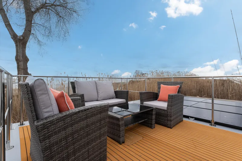 Slide: The Image of Outdoor seating area on Waterlodge Apart M 2024 with wicker furniture and scenic view. - 18