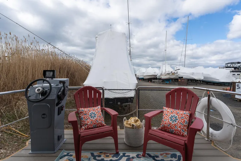 Slide: The Image of Waterlodge Apart M 2024 model with red chairs on deck, steering console, and marina view. - 21