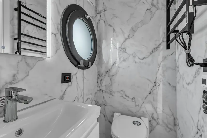 Slide: The Image of Modern bathroom in Waterlodge Apart M 2024 with marble walls and round window. - 29