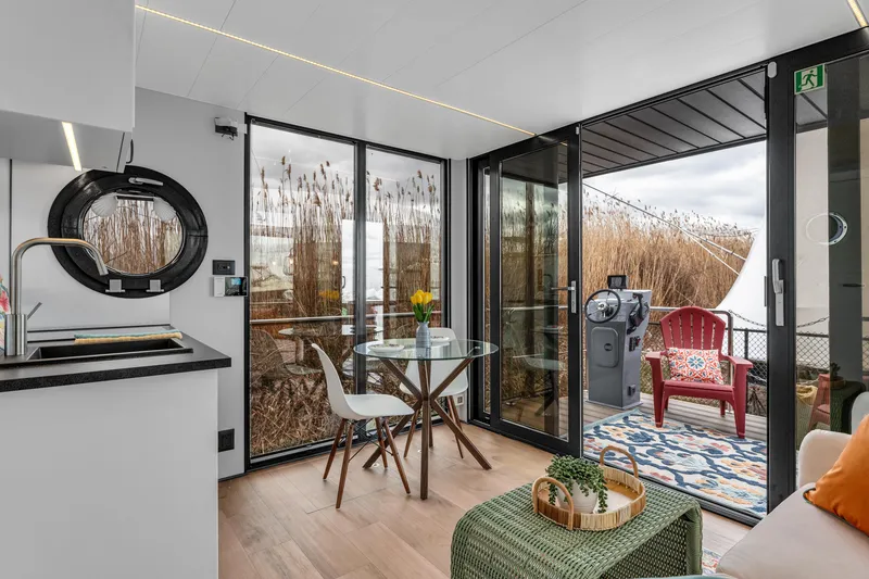 Slide: The Image of Modern Waterlodge Apart M 2024 interior with kitchen, dining area, and outdoor seating. - 6