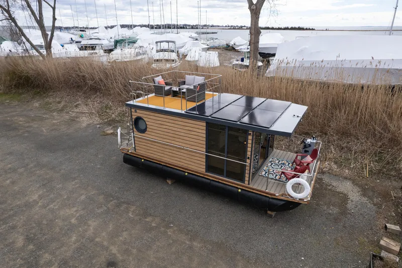 Slide: The Image of 2024 Waterlodge Apart M houseboat with rooftop deck, docked near a marina. - 9