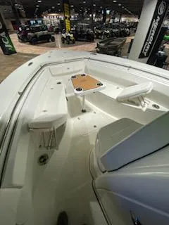 Slide: The Image of 2024 Sea Pro 259 Sport boat interior with seating and table in showroom. - 12