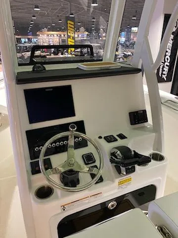Slide: The Image of 2024 Sea Pro 259 Sport boat dashboard with steering wheel and electronic controls. - 8