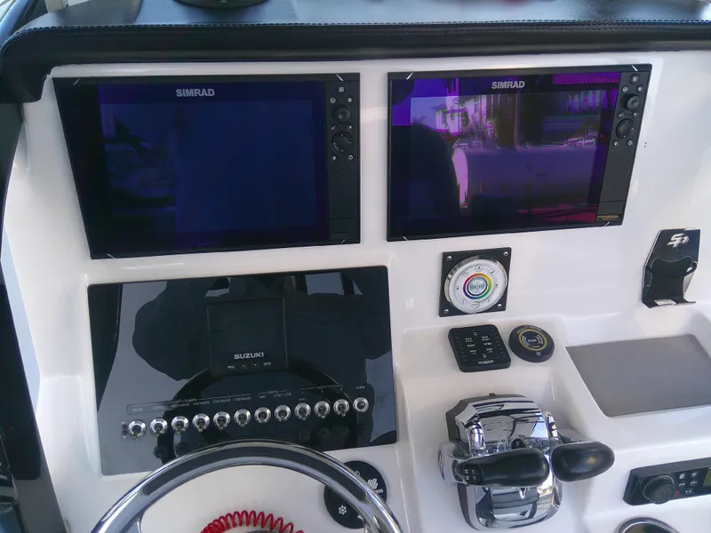 Slide: The Image of 2020 Sea Pro 259 Center Console dashboard with dual Simrad displays and controls. - 15
