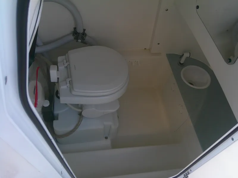 Slide: The Image of 2020 Sea Pro 259 Center Console boat bathroom interior with toilet and sink. - 24