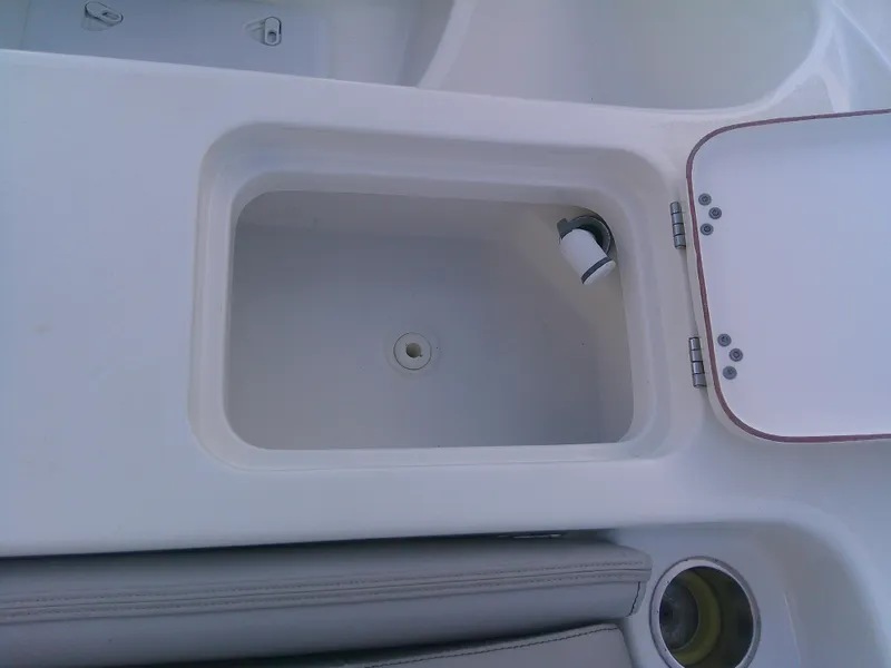 Slide: The Image of Sea Pro 259 Center Console 2020 boat storage compartment with open lid. - 39